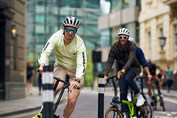 2 5th floor members riding Bromptons through London