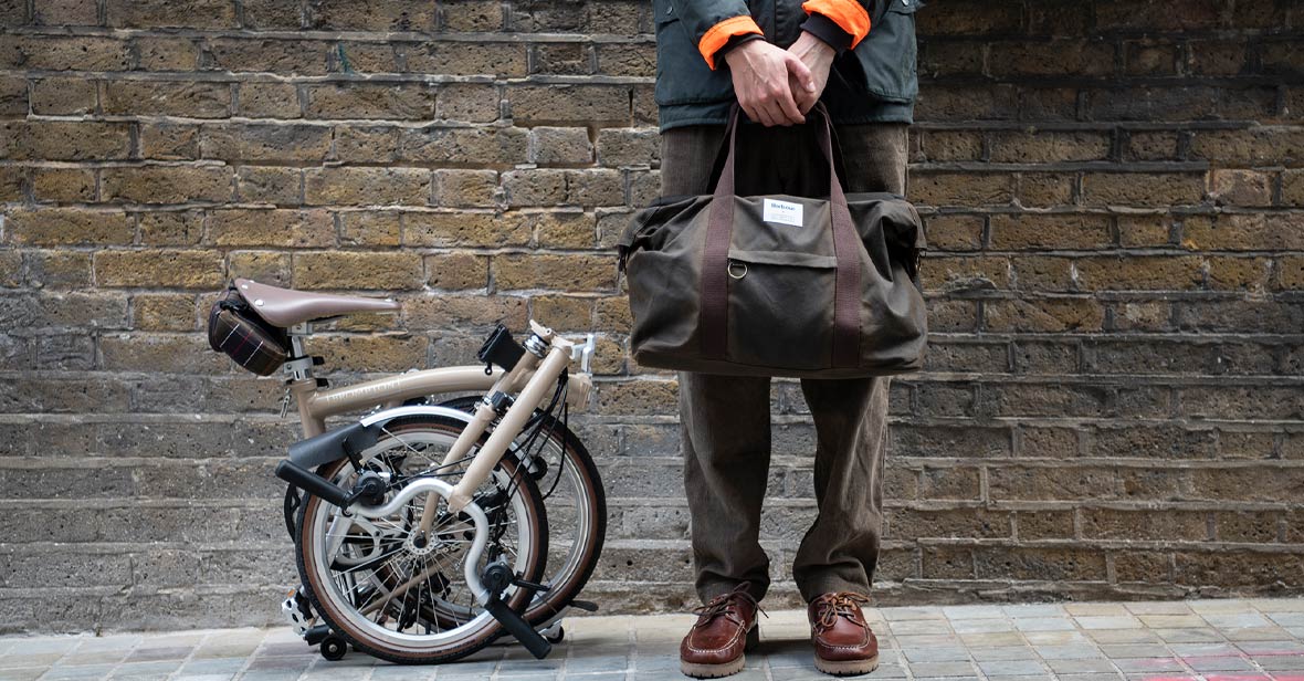 Folded bike with man holding Barbour bag
