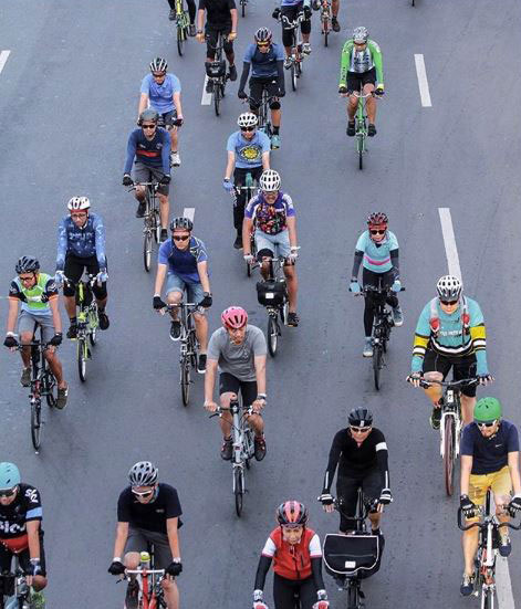 Birds eye view of multiple people riding Brompton bikes on a road