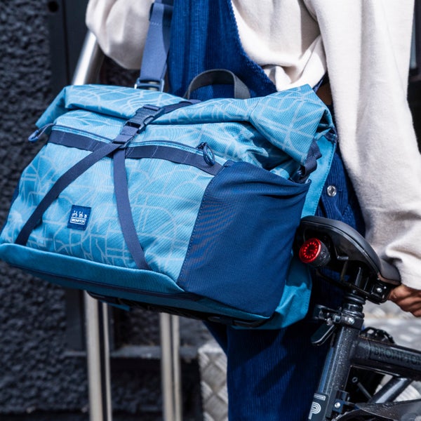 A person carrying the Brompton Bright Nights luggage tote on their back