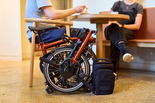 lifestyle shot a flame lacquer brompton folded under table