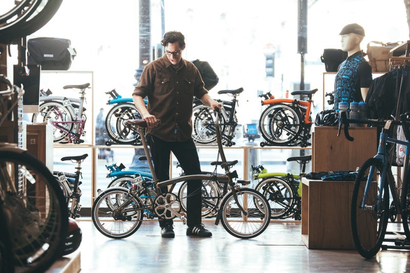 Person testing Brompton bike in store