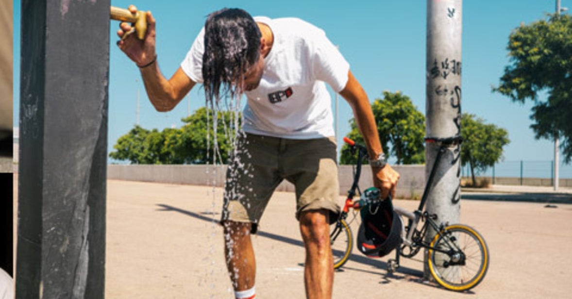 A man cooling off with water on his head with a Brompton x CHPT3 leaning behind him