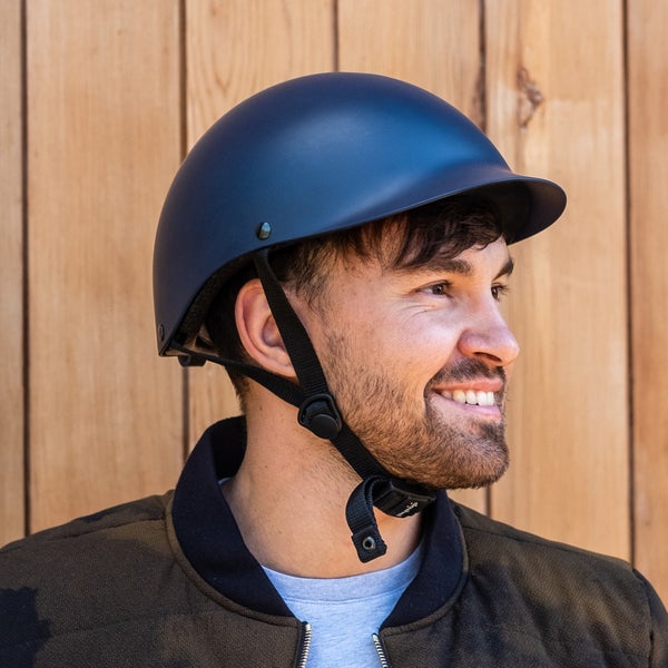 A smiling man wearing the Dashel helmet in navy