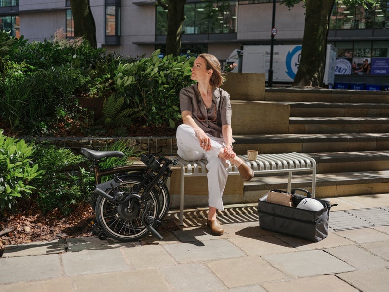 manchester brompton photo shoot woman sat with folded brompton