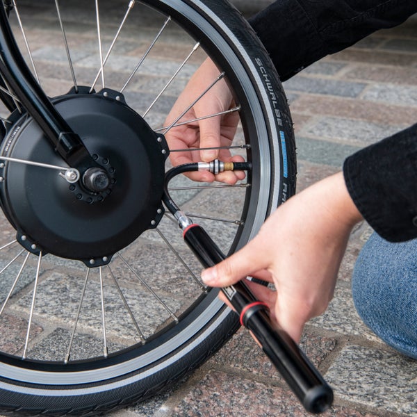 A close up image of a person using the Brompton pump with mounting brackets