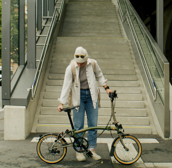 Clara Johanna with her Brompton x Bear Grylls folding bike at the bottom of a set of stairs